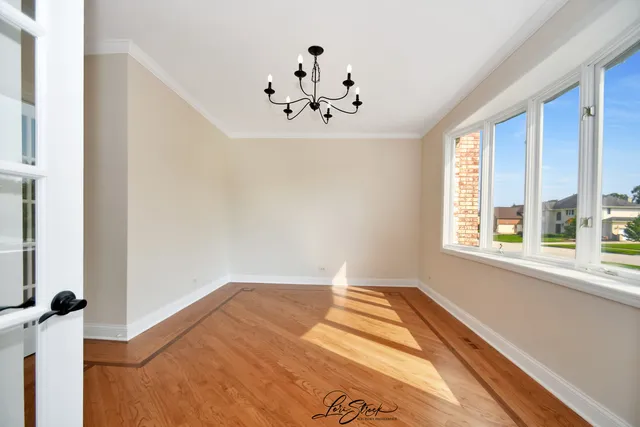 a view of a bedroom with wooden floor and a window