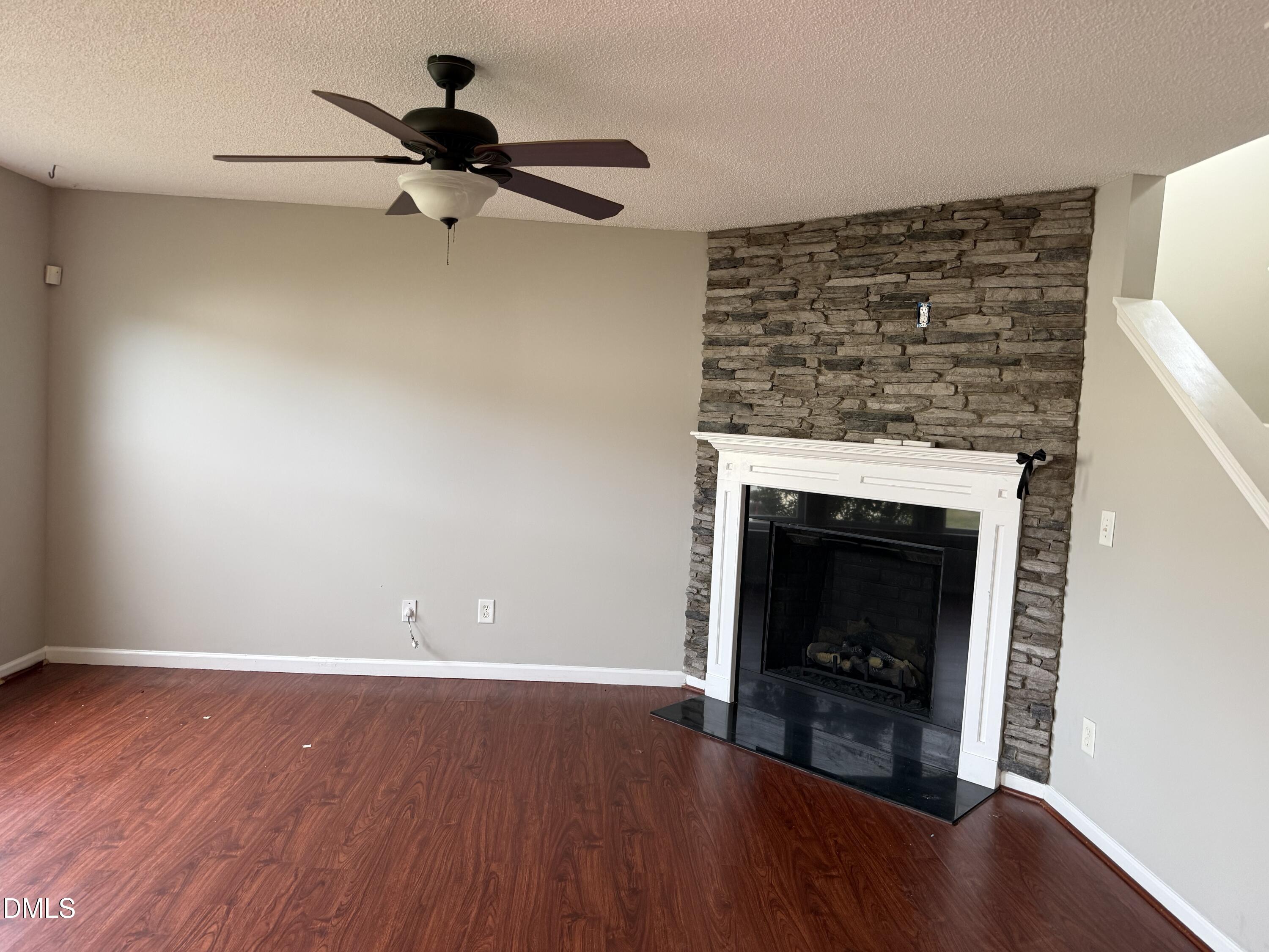 3133 Mackinac Island Lane Raleigh, NC 27610 - Photo 9 of 19 a view of a livingroom with a fireplace a ceiling fan and wooden floor