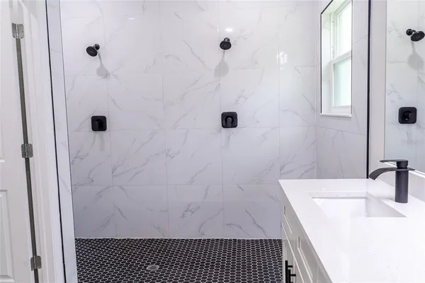 a bathroom with a sink a shower and a mirror