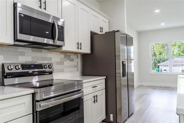 a kitchen with stainless steel appliances a stove microwave and refrigerator