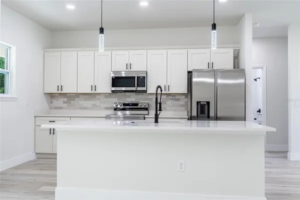 a kitchen with stainless steel appliances a refrigerator sink and microwave