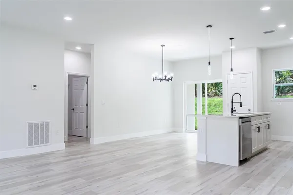 a kitchen with stainless steel appliances granite countertop a refrigerator a stove a sink and a wooden floors