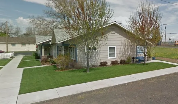 a front view of a house with a yard and trees