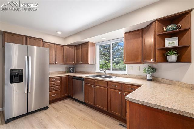 4514 Ridgeglen Road Colorado Springs, CO 80918 - Photo 9 of 29 Kitchen featuring appliances with stainless steel finishes, light wood color LVP floors, light countertops, open shelves, and recessed lighting