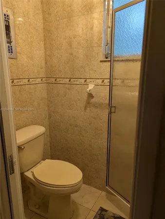 a bathroom with a toilet and a shower