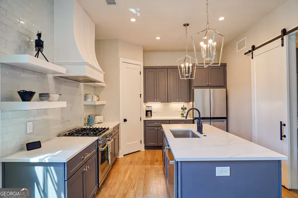 a kitchen with kitchen island a sink stove and refrigerator