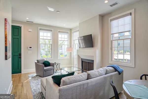 a living room with furniture a flat screen tv and a fireplace