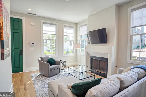 a living room with furniture a fireplace and a flat screen tv