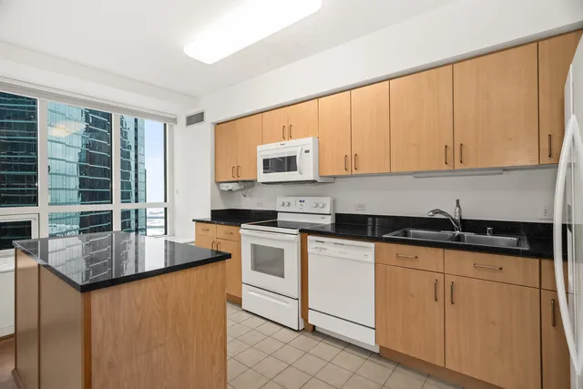 a kitchen with granite countertop a sink a stove and cabinets