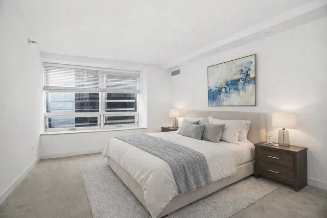 a bedroom with a bed and a large window