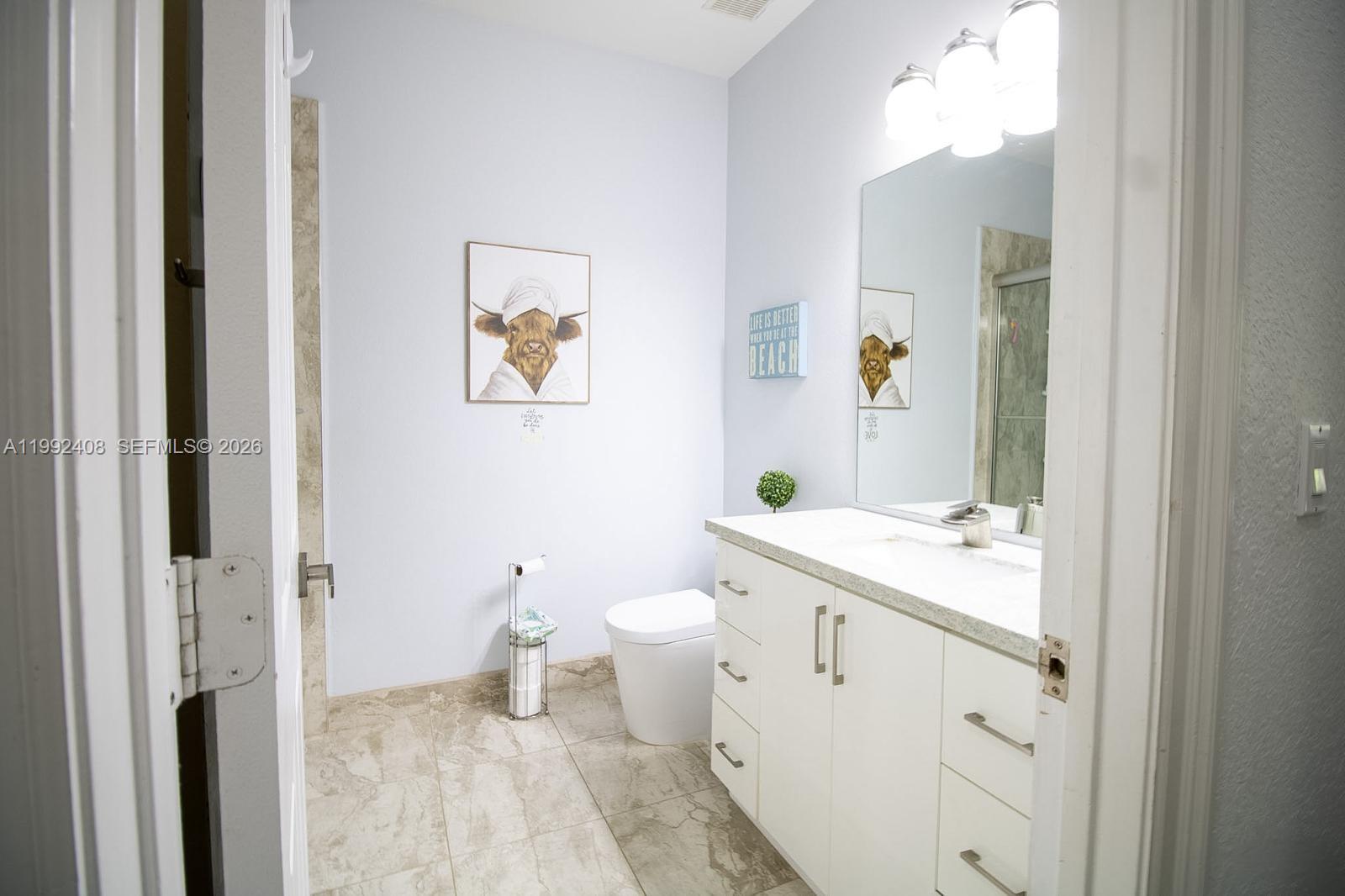 2607 Southwest 99th Way Miramar, FL 33025 - Photo 25 of 50 a spacious bathroom with a toilet sink and a mirror