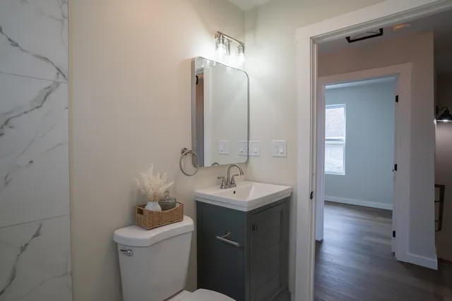 a bathroom with a sink toilet and mirror