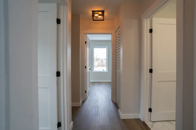 a view of a hallway with wooden floor