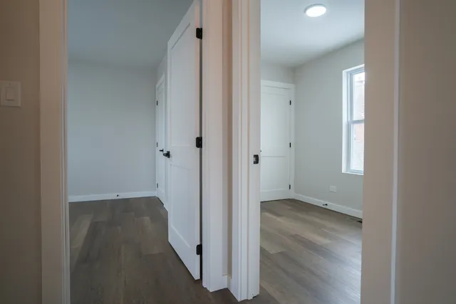 an empty room with wooden floor and a window