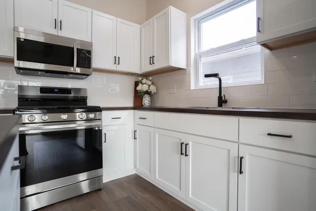 a kitchen with granite countertop a sink appliances cabinets and a counter top space