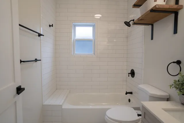 a bathroom with a shower a toilet and a tub