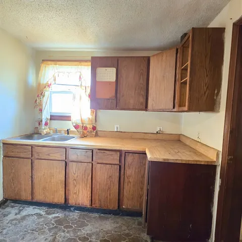 a room with granite countertop cabinets sink and window