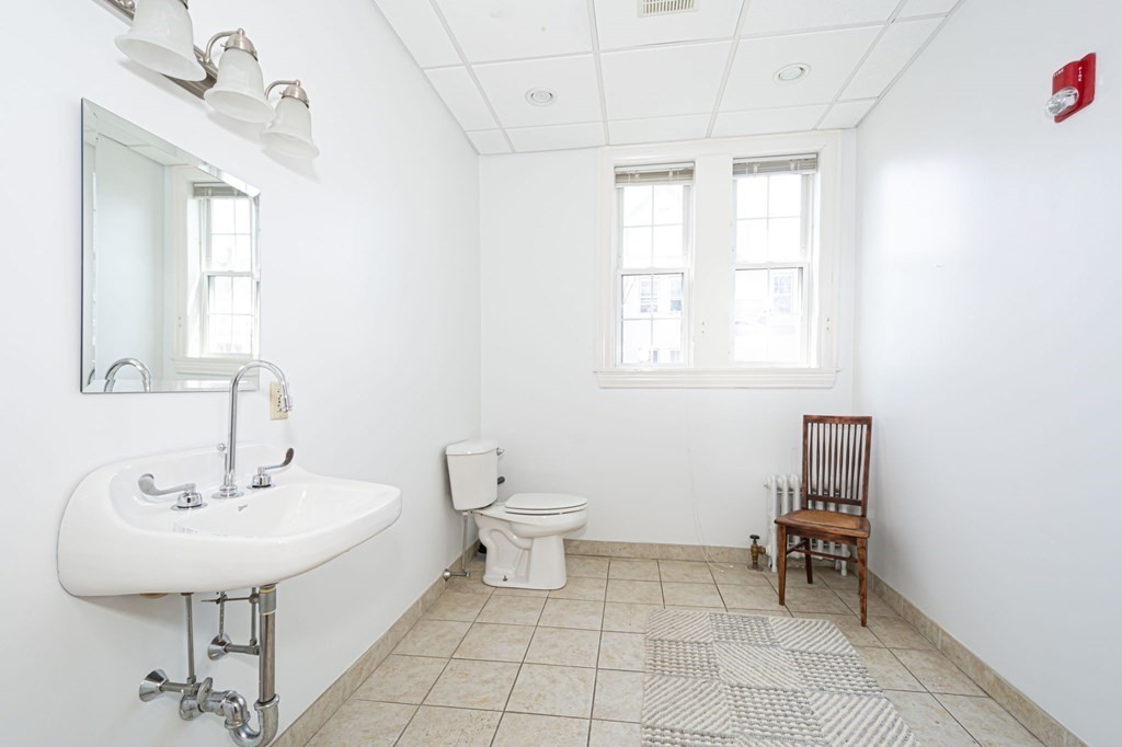 56 William Street Worcester, MA 01609 - Photo 15 of 37 a bathroom with a sink a toilet and mirror