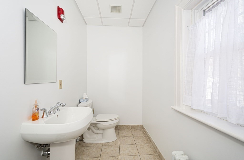 56 William Street Worcester, MA 01609 - Photo 18 of 37 a bathroom with a sink a mirror and a toilet