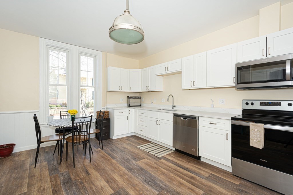 56 William Street Worcester, MA 01609 - Photo 10 of 37 a kitchen with a table chairs microwave and cabinets