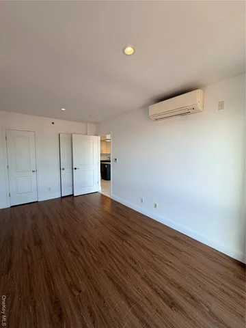 a view of a room with wooden floors and white walls