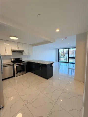 a large kitchen with a large counter top and stainless steel appliances
