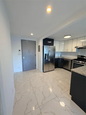 a large kitchen with kitchen island a sink stainless steel appliances and cabinets