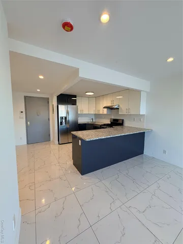 a large kitchen with stainless steel appliances granite countertop a stove and a sink