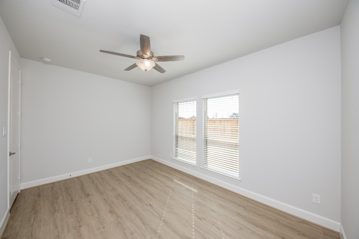 29819 Breezy Pnes Loop Fulshear, TX 77441 - Photo 12 of 50 wooden floor in an empty room with a window
