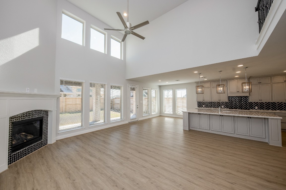 29819 Breezy Pnes Loop Fulshear, TX 77441 - Photo 19 of 50 a view of an empty room with wooden floor and a kitchen