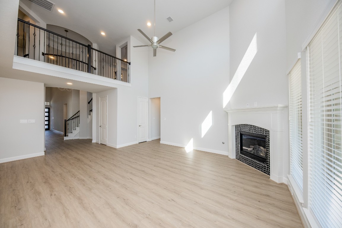 29819 Breezy Pnes Loop Fulshear, TX 77441 - Photo 21 of 50 an empty room with wooden floor fireplace and windows