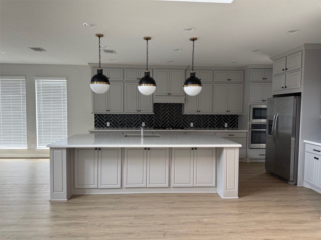 29819 Breezy Pnes Loop Fulshear, TX 77441 - Photo 23 of 50 a view of a kitchen with stainless steel appliances granite countertop a stove a sink and a wooden floors
