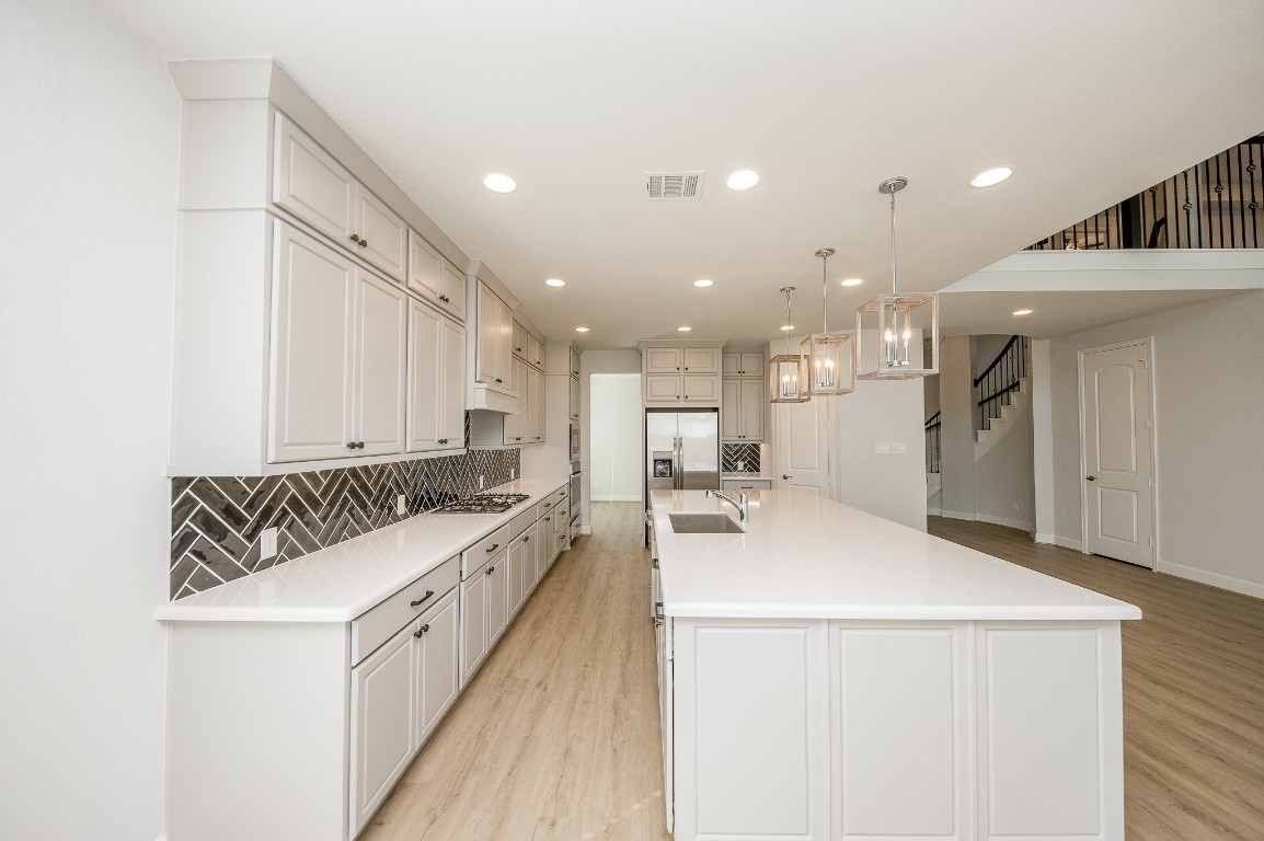 29819 Breezy Pnes Loop Fulshear, TX 77441 - Photo 26 of 50 a large white kitchen with a large window and stainless steel appliances