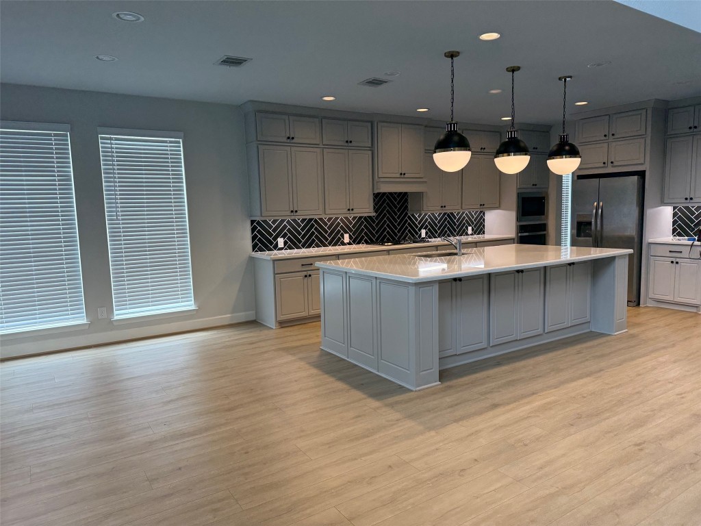 29819 Breezy Pnes Loop Fulshear, TX 77441 - Photo 28 of 50 a large kitchen with stainless steel appliances granite countertop a stove and a wooden floors