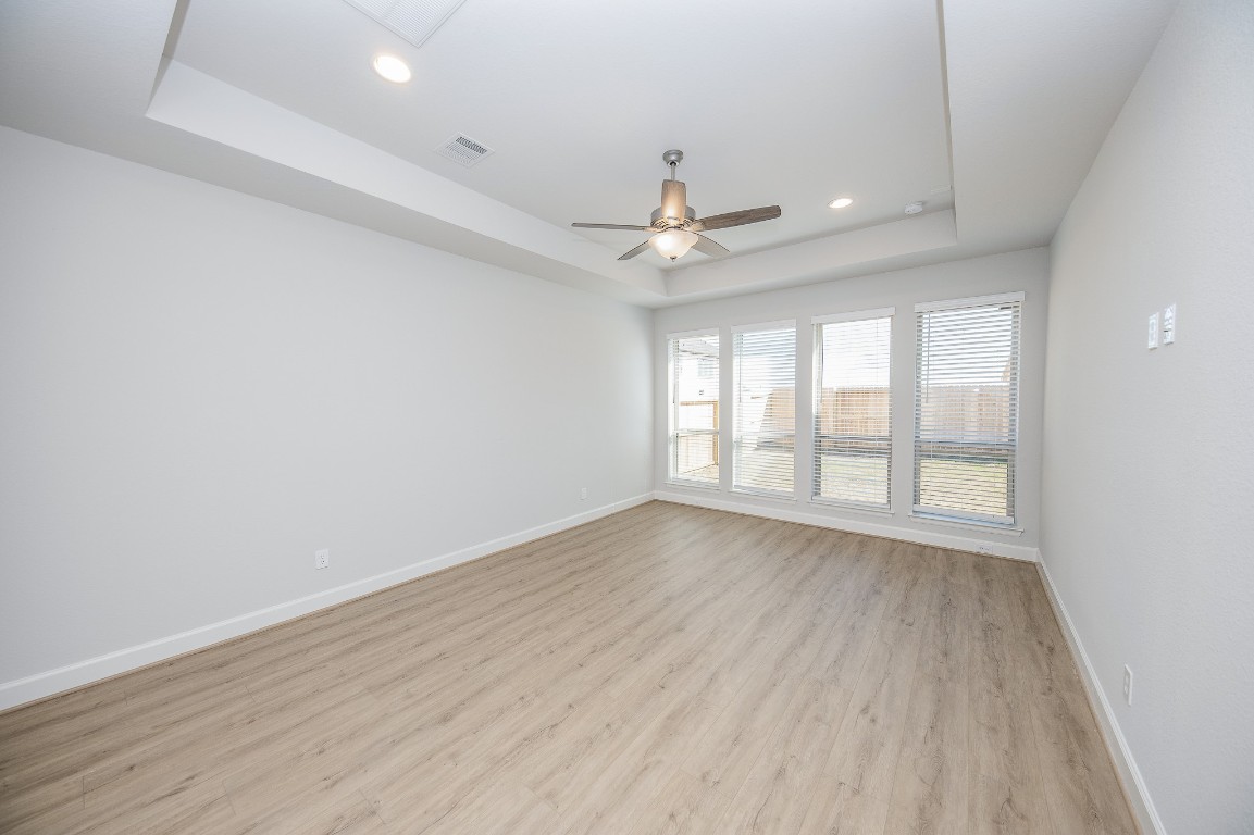 29819 Breezy Pnes Loop Fulshear, TX 77441 - Photo 34 of 50 an empty room with wooden floor and windows