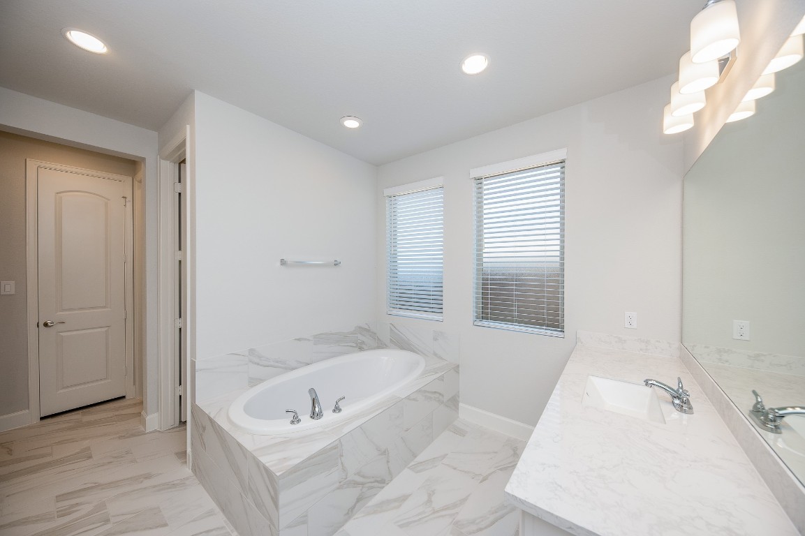 29819 Breezy Pnes Loop Fulshear, TX 77441 - Photo 36 of 50 a bathroom with a tub a sink and a large mirror