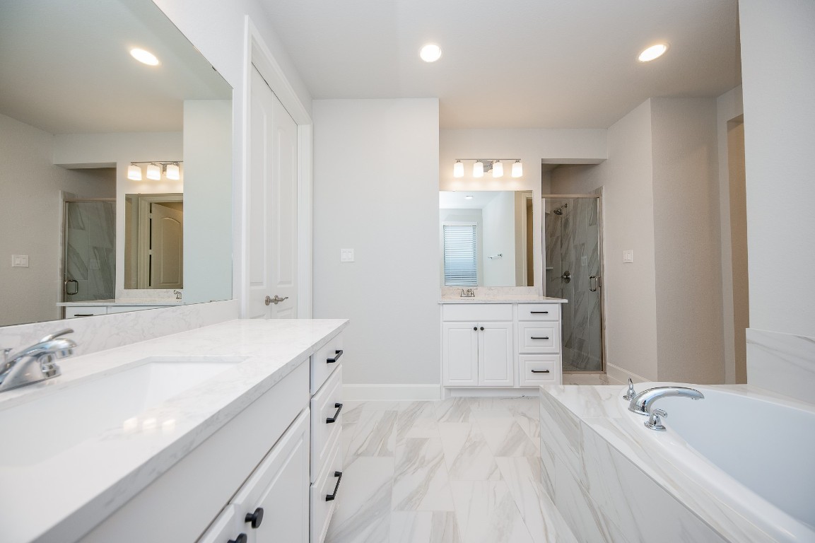 29819 Breezy Pnes Loop Fulshear, TX 77441 - Photo 37 of 50 a bathroom with a tub a sink and mirror