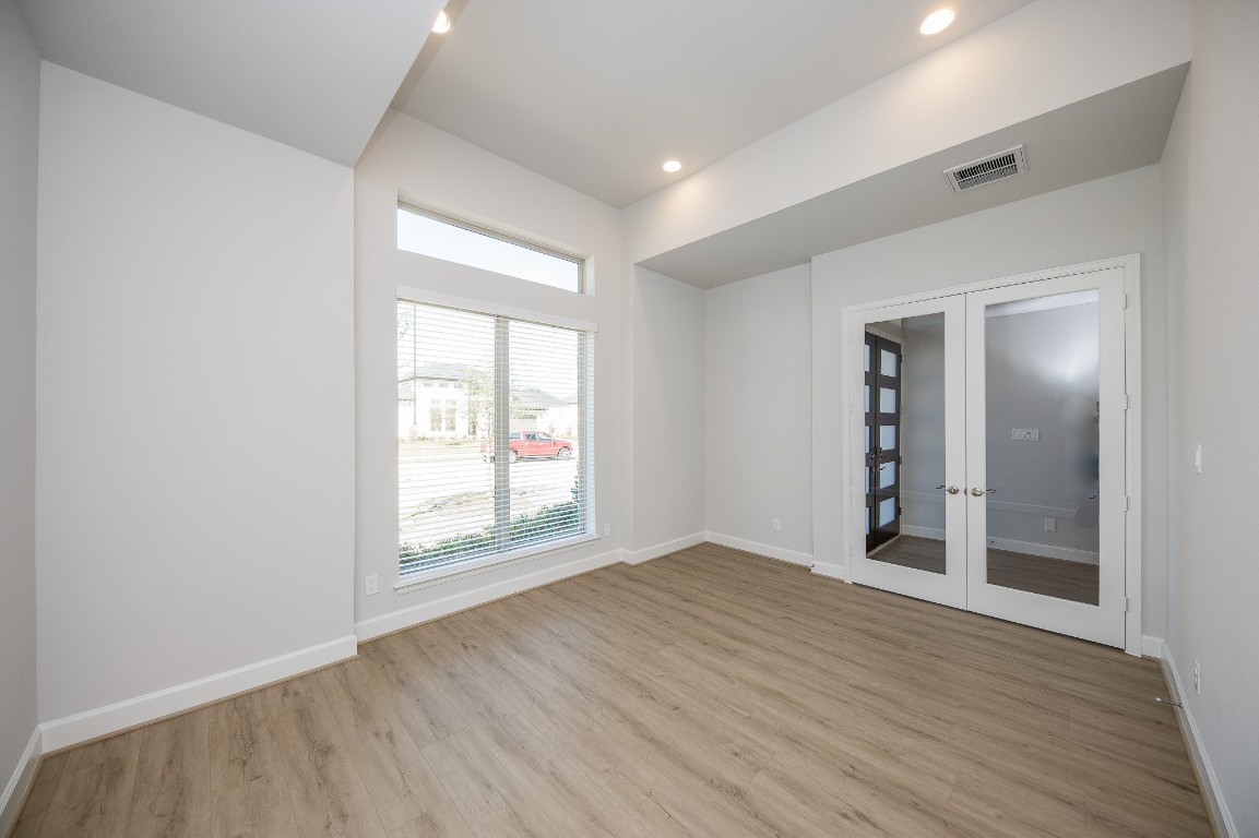 29819 Breezy Pnes Loop Fulshear, TX 77441 - Photo 7 of 50 an empty room with wooden floor and windows