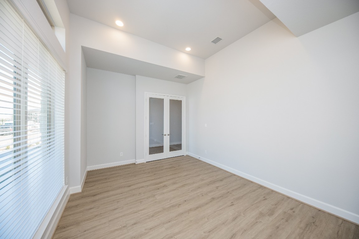 29819 Breezy Pnes Loop Fulshear, TX 77441 - Photo 8 of 50 a view of an empty room with wooden floor and a window