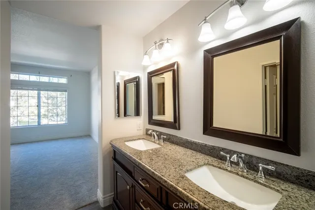 a bathroom with double sink and a mirror