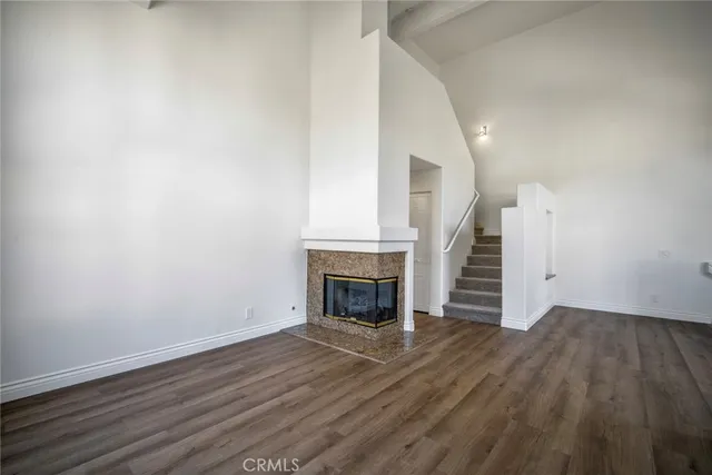 an empty room with wooden floor and fireplace
