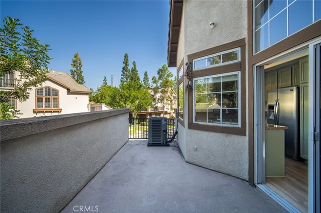 a view of a house with a large window and potted plants