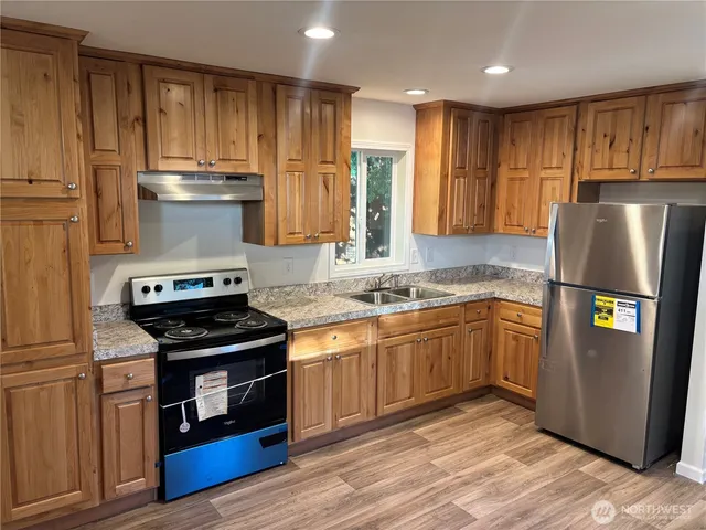 a kitchen with stainless steel appliances granite countertop a stove refrigerator and cabinets