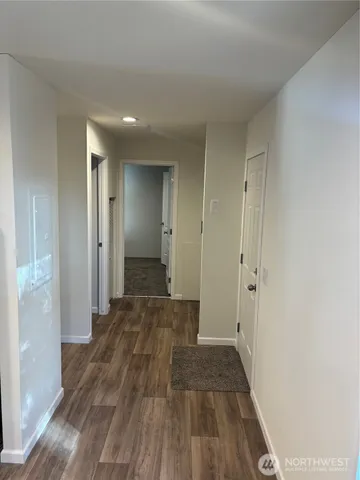 a view of a room with wooden floor and a bathroom