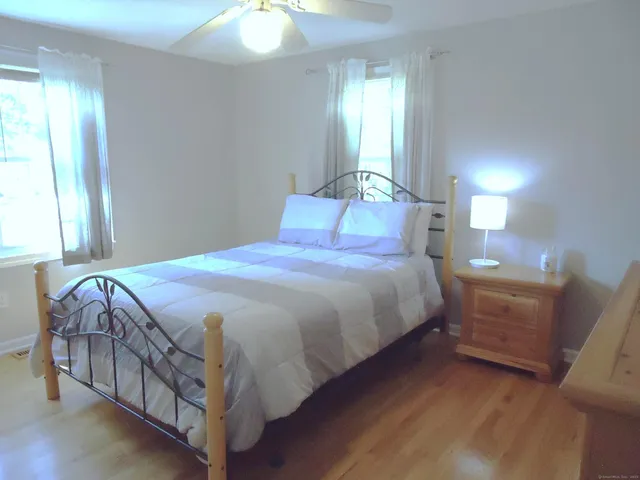 a bedroom with a bed a mirror and lamp