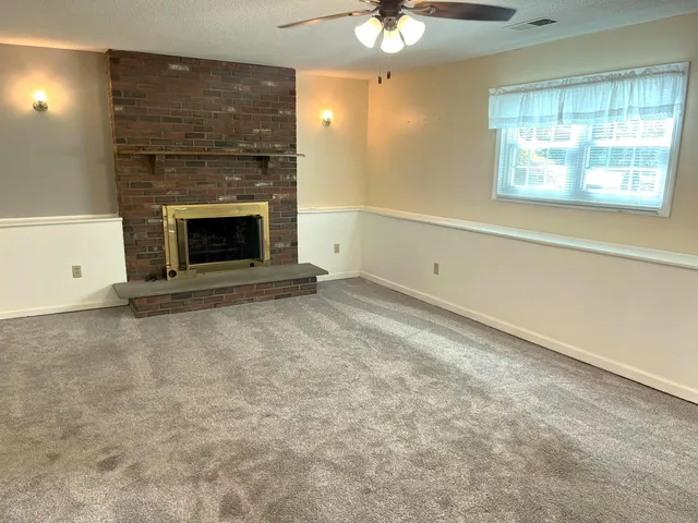 an empty room with a fireplace and fan