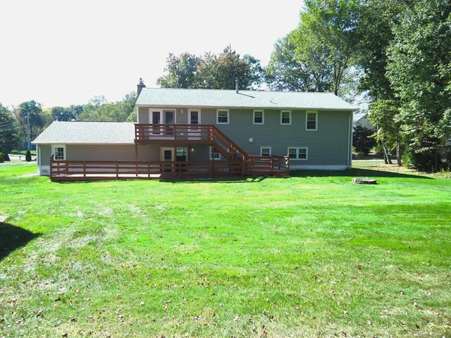 a view of a house with a yard and sitting area