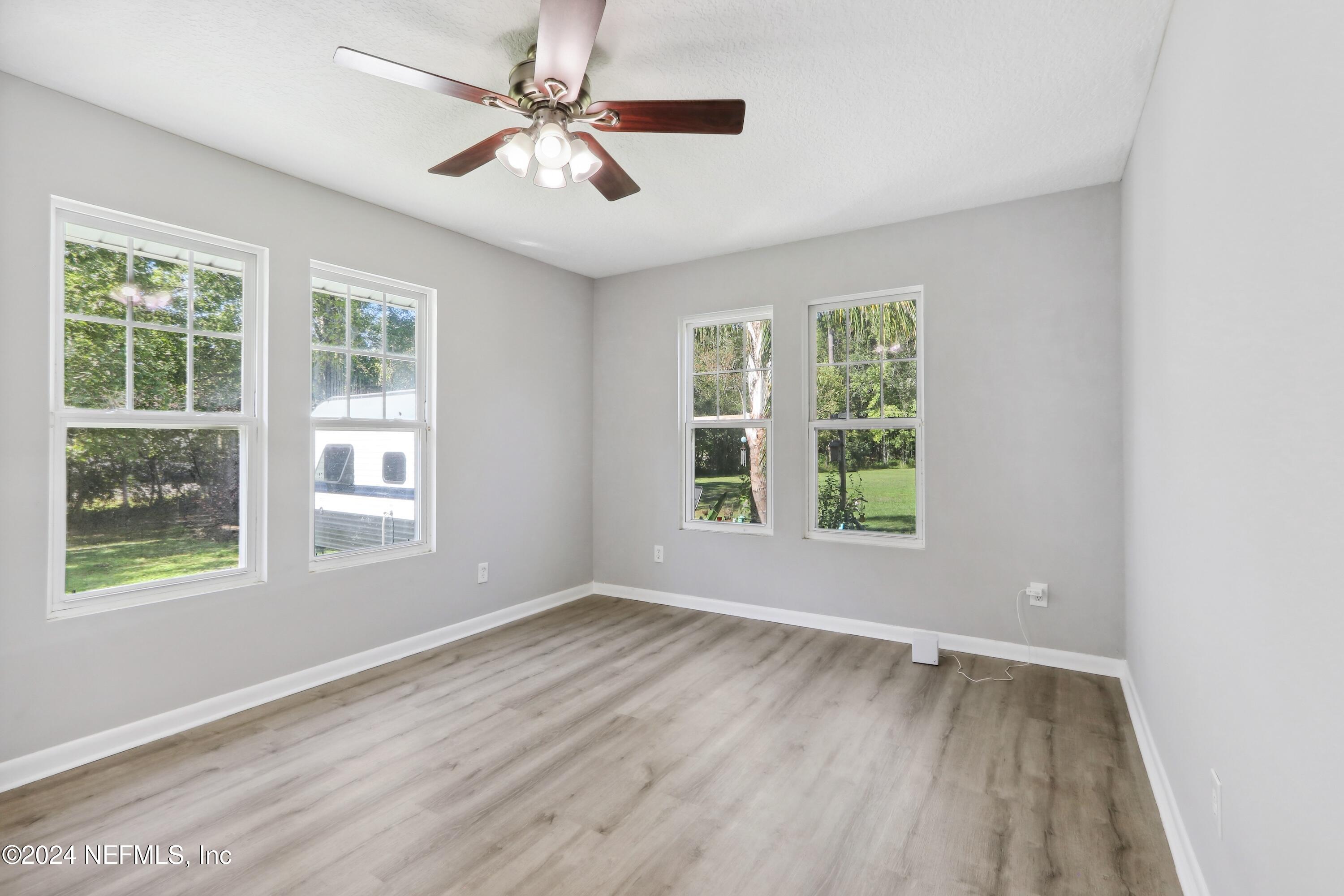 3629 Capper Road Jacksonville, FL 32218 - Photo 11 of 26 a view of an empty room with wooden floor and a window
