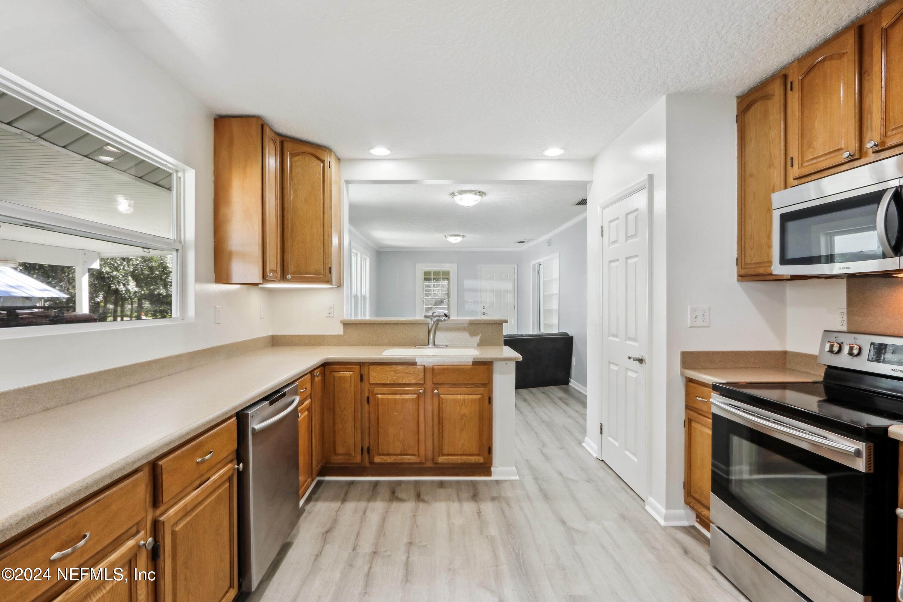 3629 Capper Road Jacksonville, FL 32218 - Photo 14 of 26 a kitchen with a sink stove and cabinets