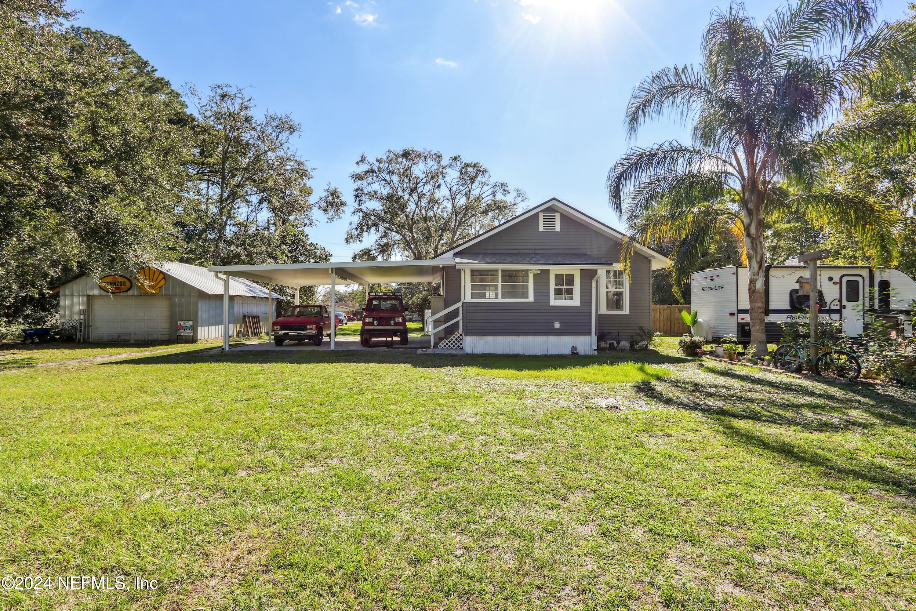 3629 Capper Road Jacksonville, FL 32218 - Photo 17 of 26 a front view of a house with a garden and swimming pool